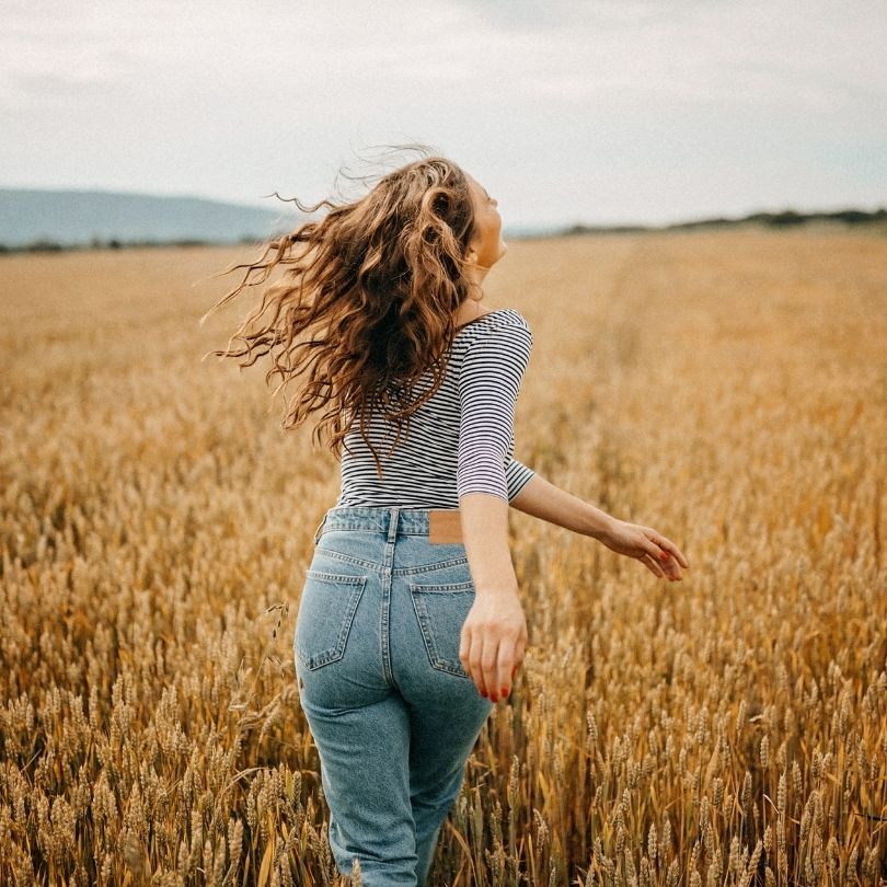 mujer corriendo por el campo feliz