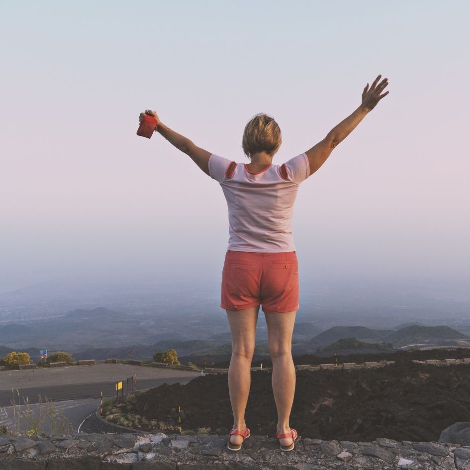 Mujer con los brazos abiertos por estar feliz 