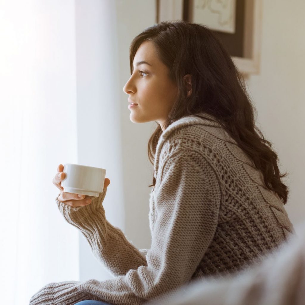 mujer con una taza de te o infusion pensando Cuál es el mejor ayuno intermitente