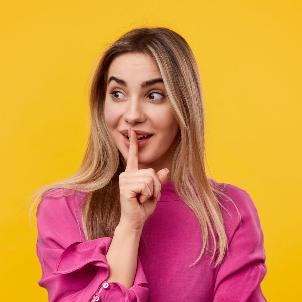 mujer con expresion de que hay que guardar un secreto