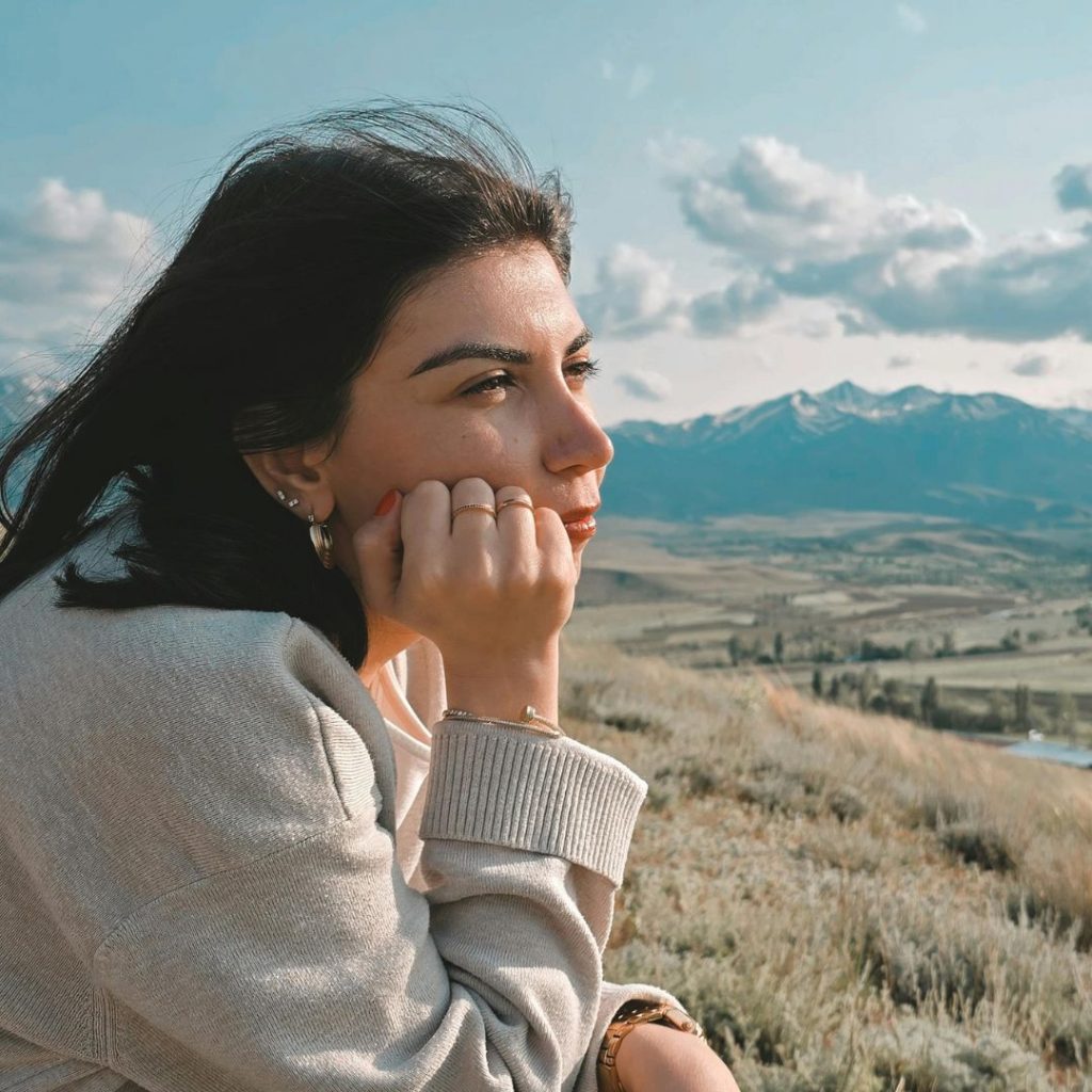 Mujer al aire libre apoyada pensando La mejor forma de hacer ayuno intermitente sin cometer errores