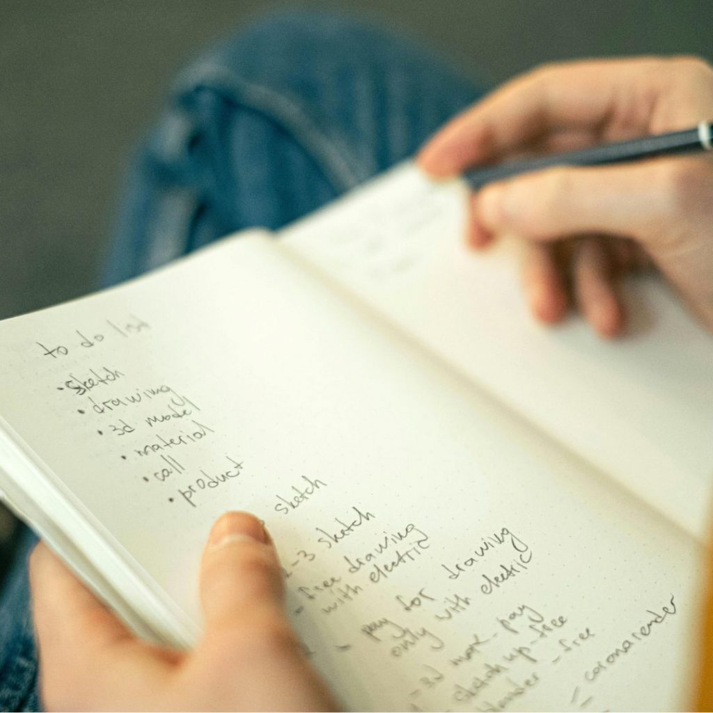 mano con un lapiz escribiendo en una libreta