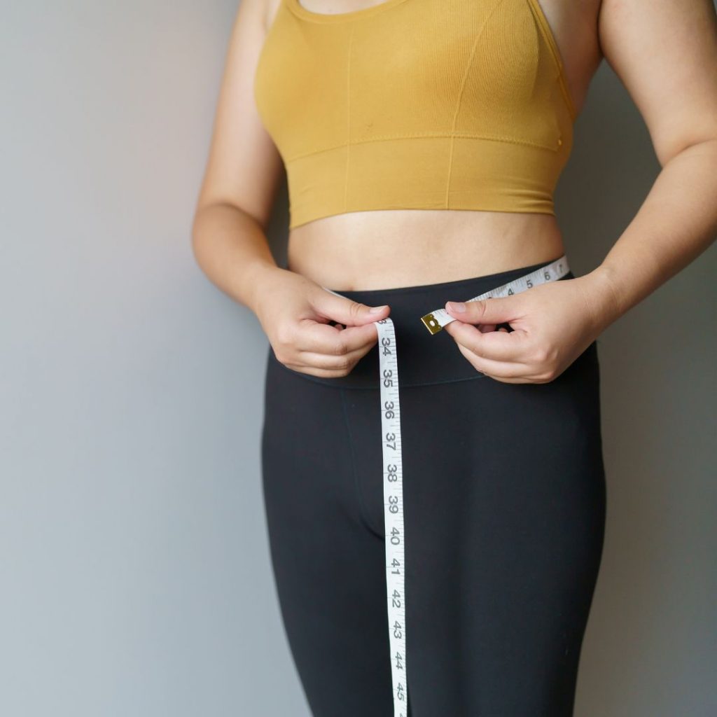 mujer midiendo su cintura