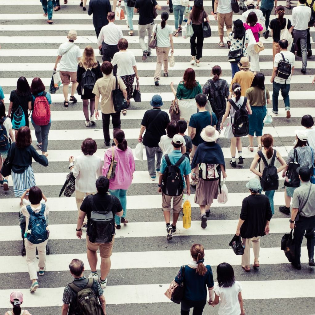 Multitud de personas caminando por un paso de peatones