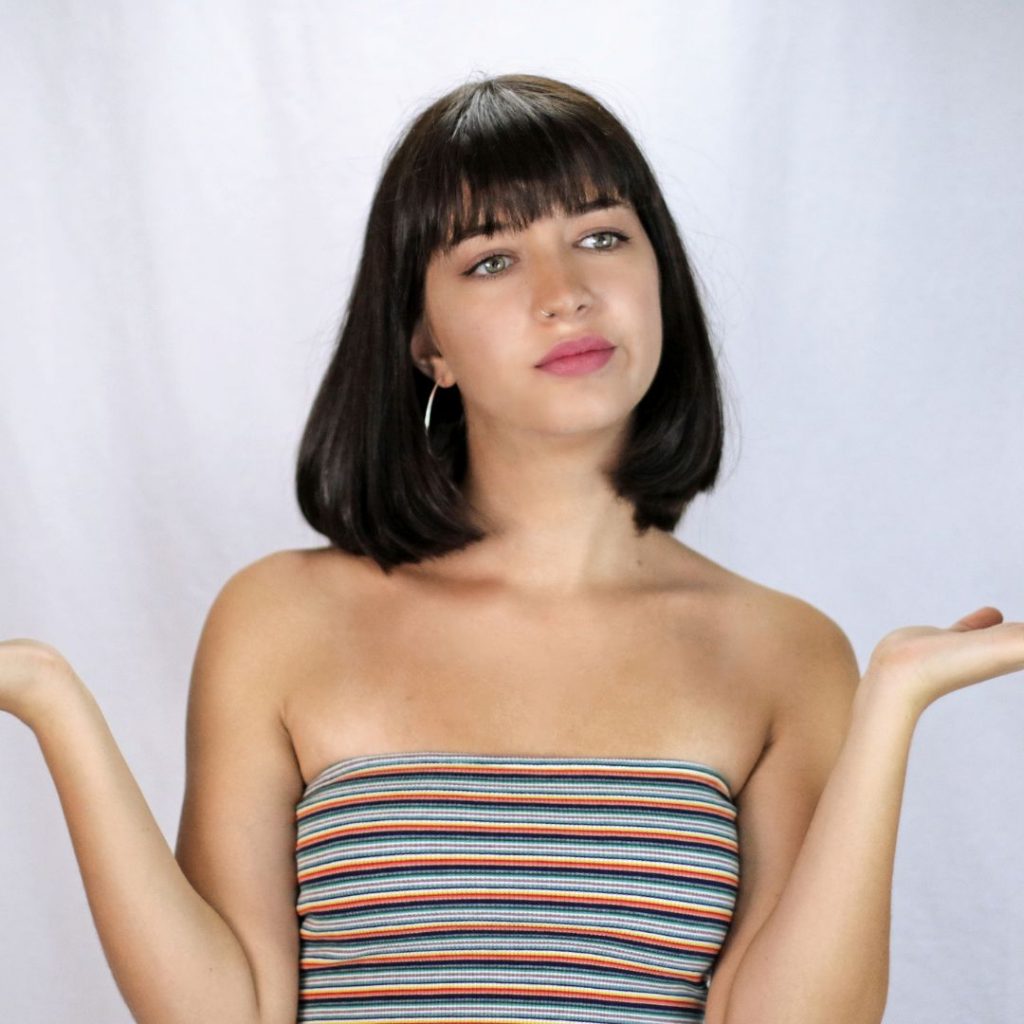 mujer con los brazos habiertos dudando con inseguridad