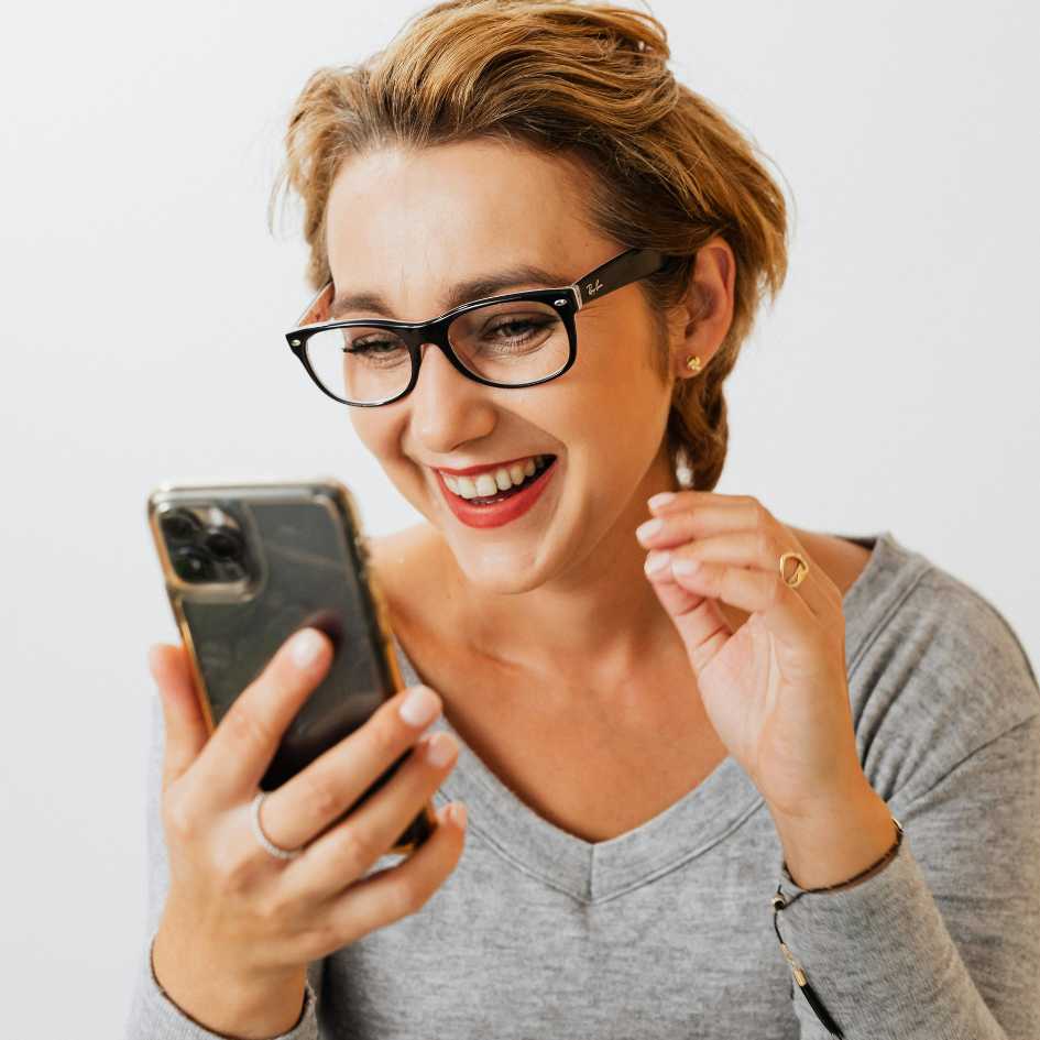 Mujer sonriendo mientras conecta con su coach — Con el Método Ayuno Personal™, nunca estarás sola en tu transformación.