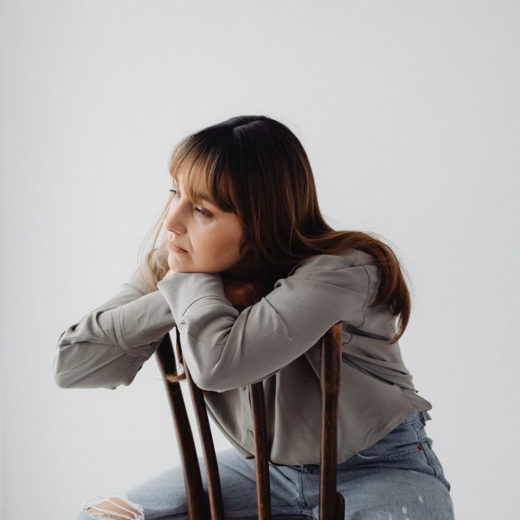 Mujer triste sentada en una silla Proceso de reflexión y cambio de mentalidad al iniciar el ayuno intermitente